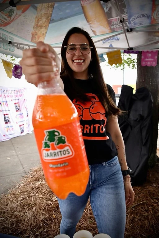 A Jarritos Mandarin bottle held close to the camera with the label visible
